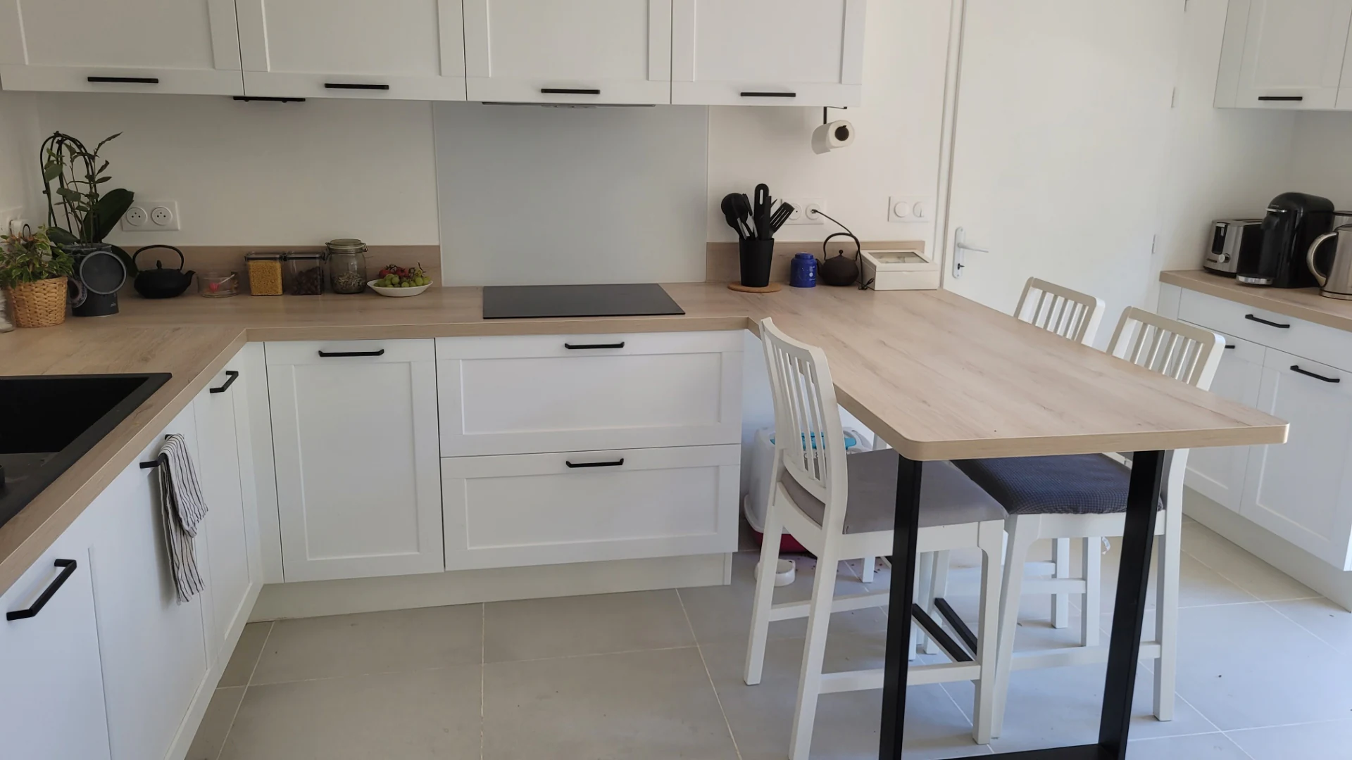 Plan de travail d’aspect bois prolongé d’une table et de chaises, réalisation MT Cuisine à Montgiscard