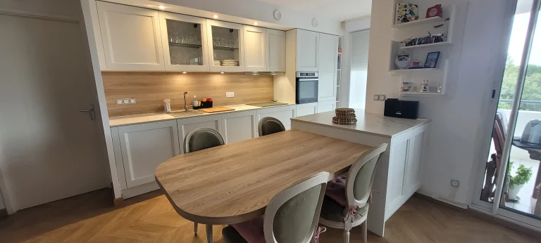 Table en stratifié effet bois et chaises près de la baie vitrée, réalisation MT Cuisine à Seilh