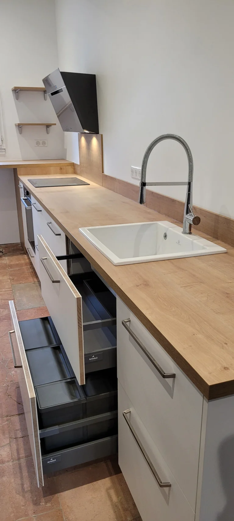Évier encastré dans le plan de travail effet bois avec tiroirs de rangement ouverts, réalisation MT Cuisine à Toulouse