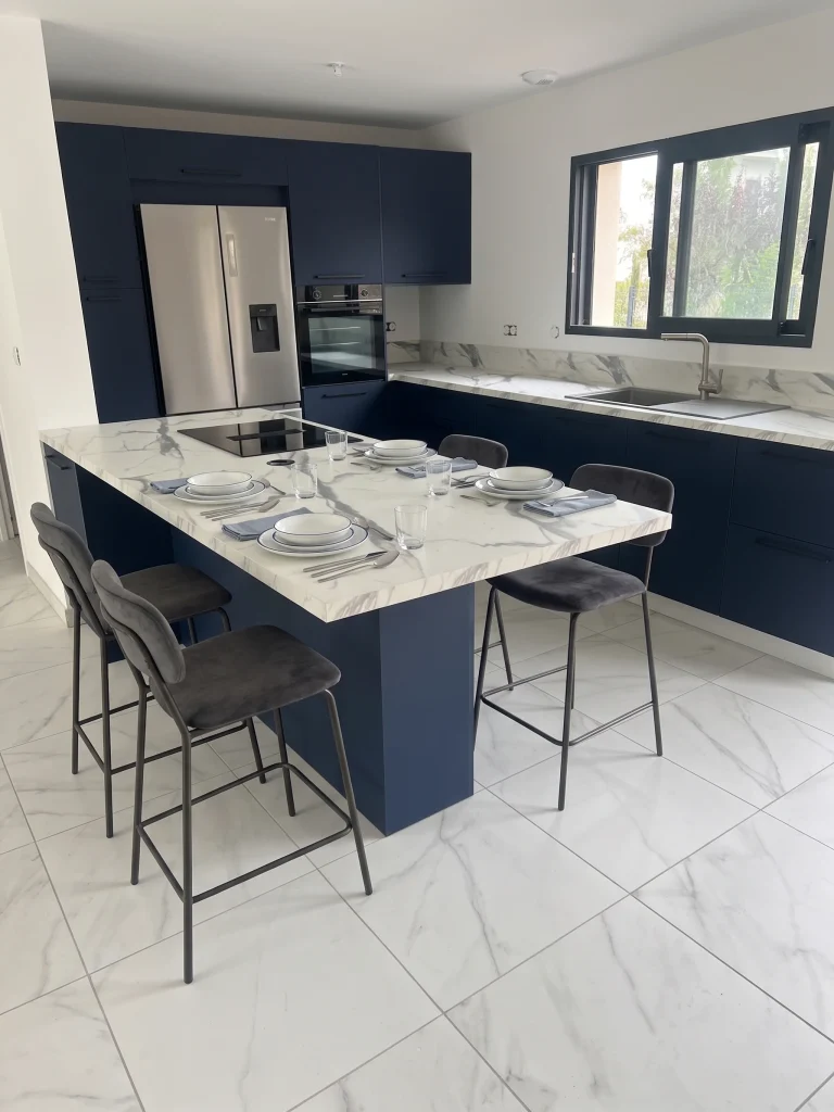 Îlot central avec façades bleues et tabourets, réalisation MT Cuisine à Launaguet