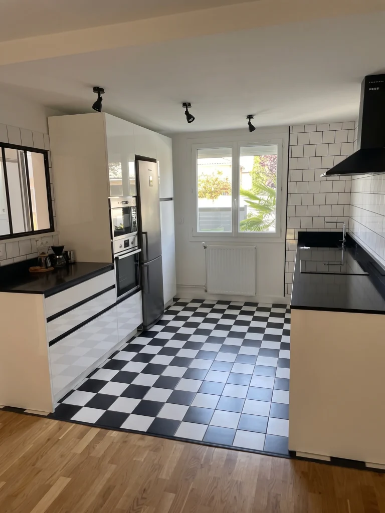 Cuisine linéaire à façades noires, crédence carreaux blancs et sol damier, réalisation MT Cuisine à Toulouse
