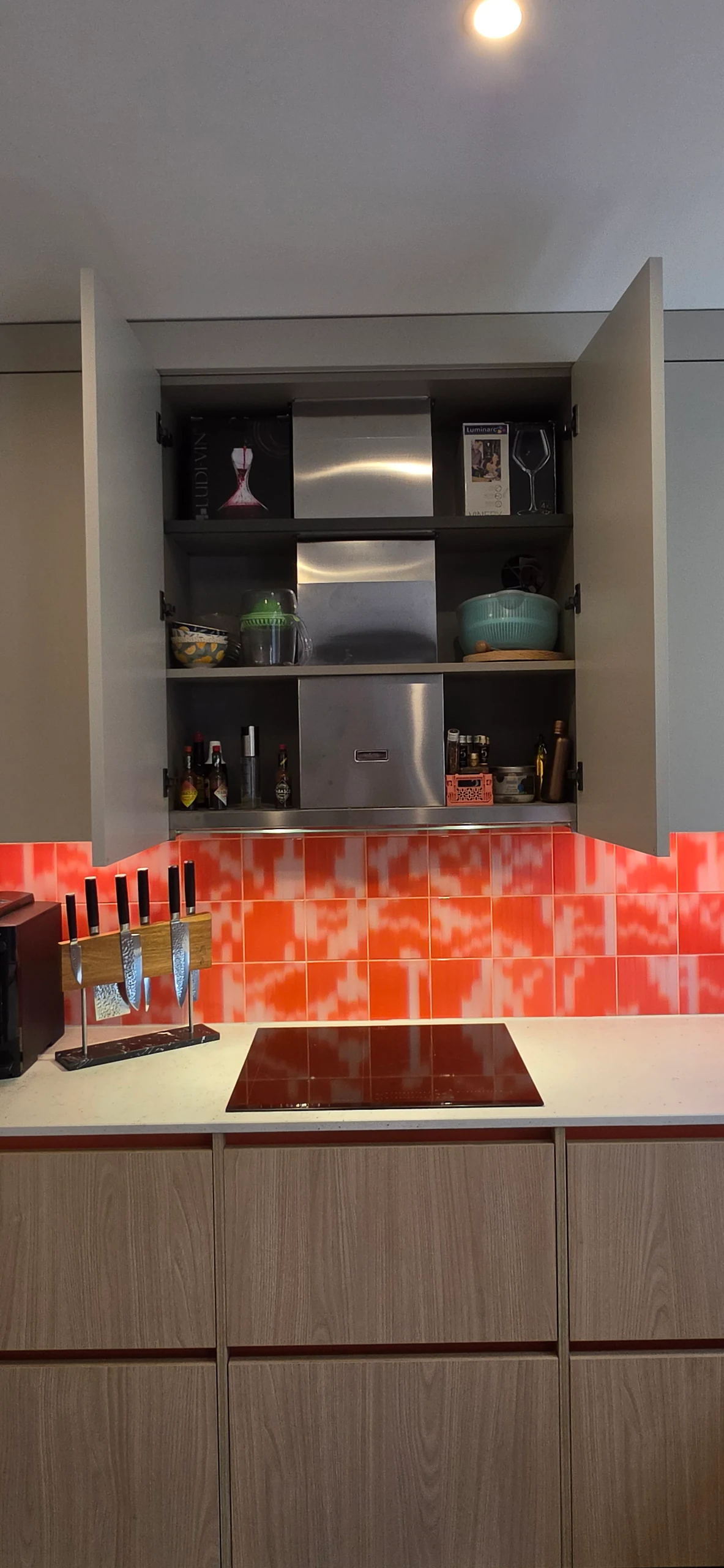 Meuble haut ouvert et éclairé au-dessus de la plaque, réalisation MT Cuisine à Toulouse
