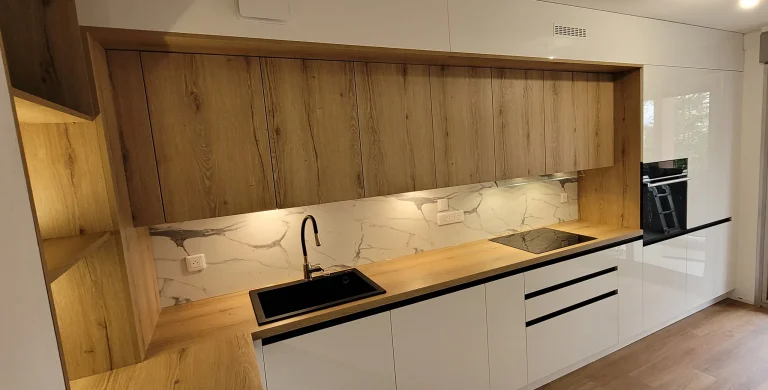 Niche éclairée au-dessus de l’évier noir et du plan stratifié effet bois, réalisation MT Cuisine à Toulouse