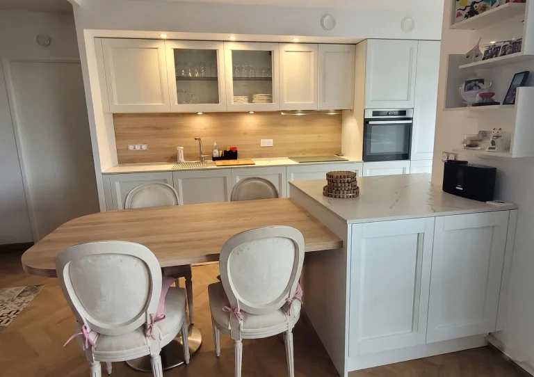 Cuisine à façades cadre avec vitrines éclairées et table en bois, réalisation MT Cuisine à Seilh