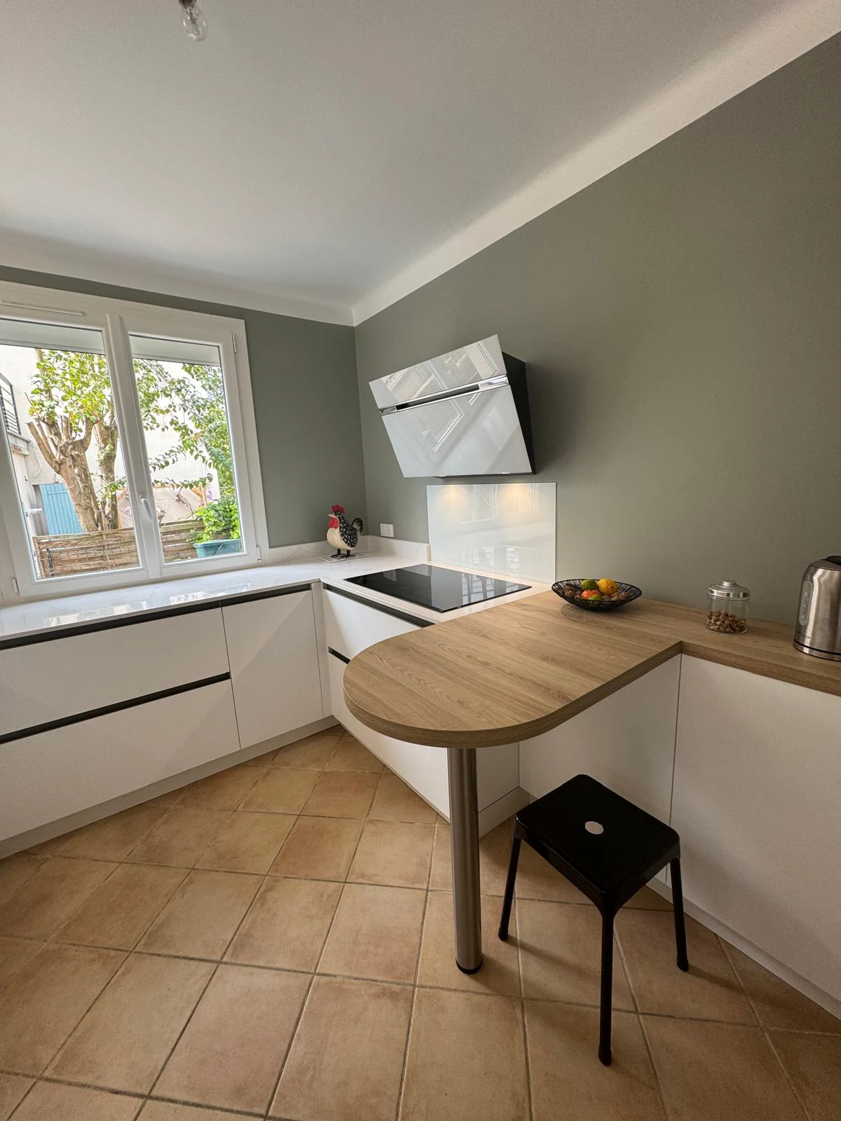 Cuisine blanche vue depuis la porte, tablette en stratifié effet bois et mur vert, réalisation MT Cuisine à Toulouse