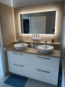 Salle de bain avec double vasque à poser, meuble blanc et miroir rétroéclairé, réalisation MT Cuisine à Auzielle