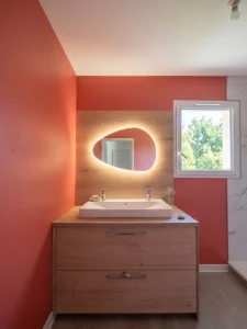 Salle de bain avec grande vasque, mur terracotta et miroir rétroéclairé, réalisation MT Cuisine à Gagnac-sur-Garonne