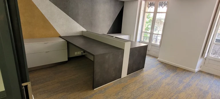 Deux postes de travail face à face devant une fenêtre, plateaux effet béton et rangements sur mesure réalisés par MT Cuisine