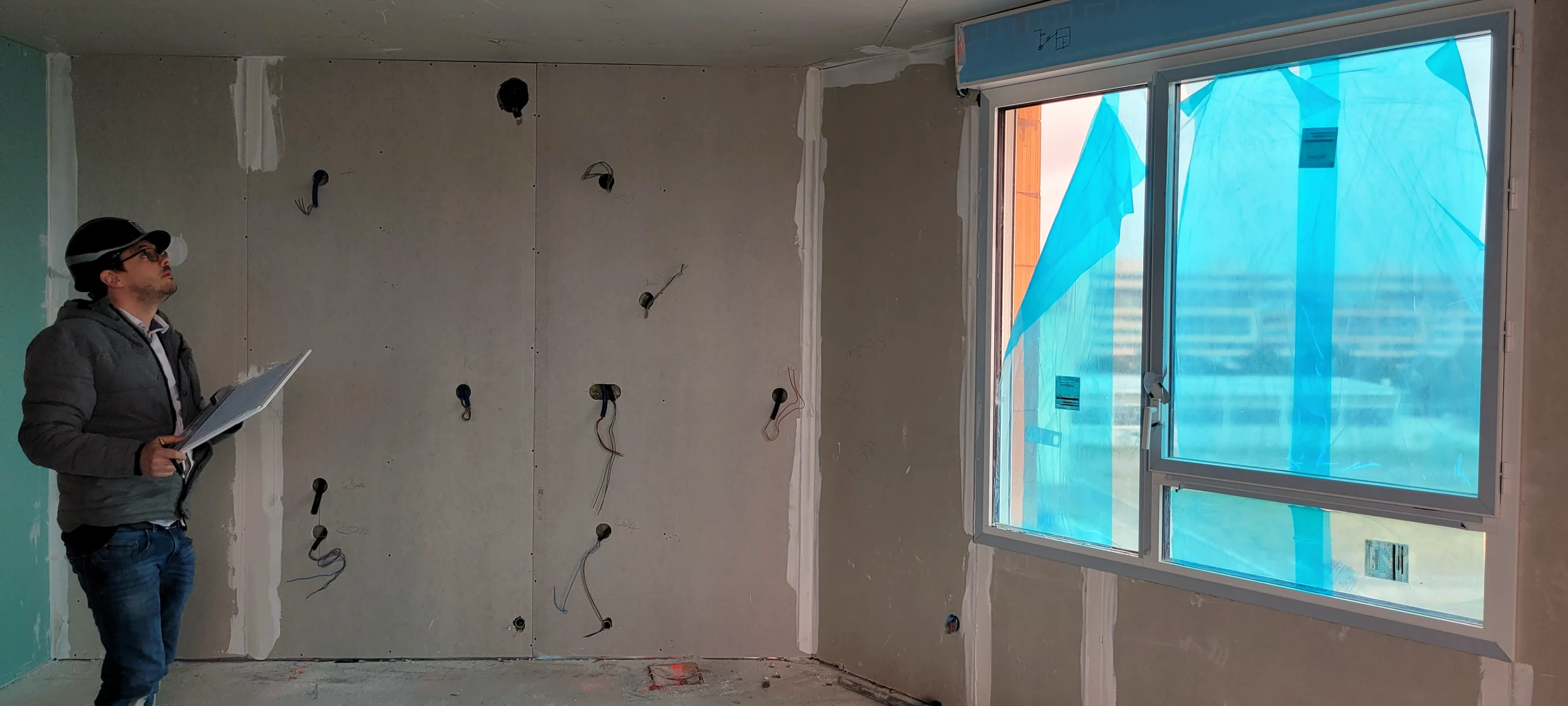 Relevé de cotes sur un chantier de cuisine : mur préparé, attentes électriques et arrivées en place avant la pose