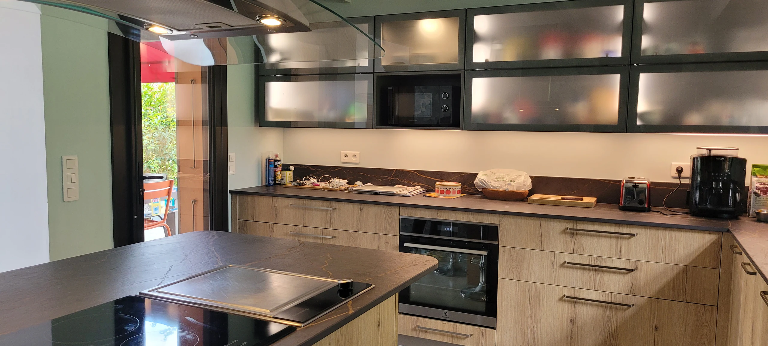 Îlot et plaque de cuisson devant la baie de la terrasse, réalisation MT Cuisine à Vigoulet-Auzil