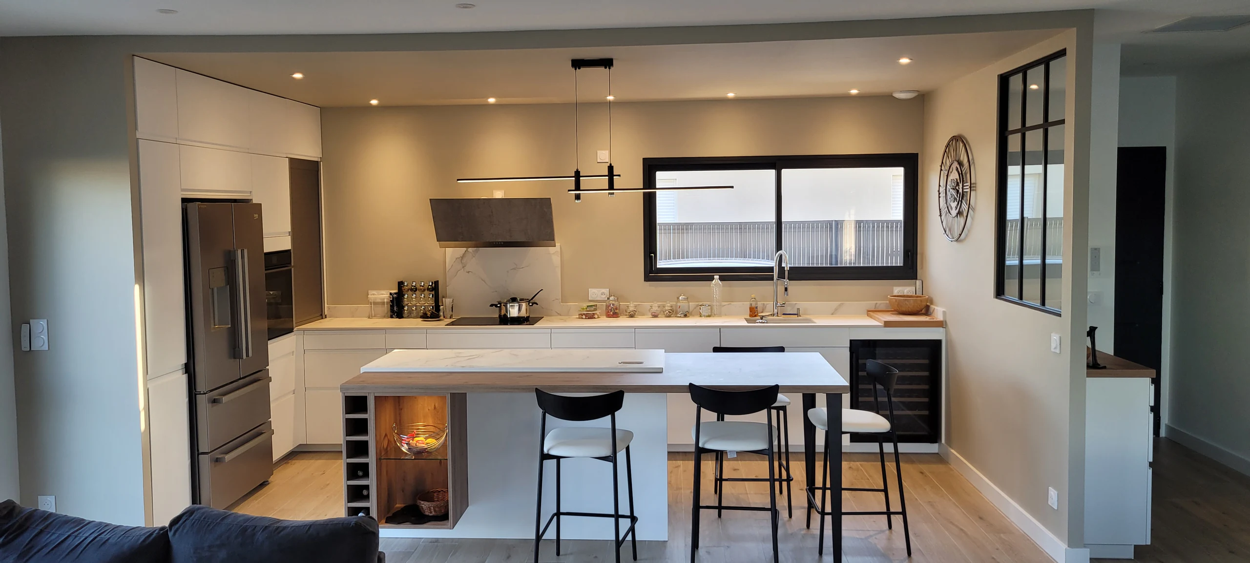 La cuisine vue depuis le salon à travers la verrière coulissante, réalisation MT Cuisine à Plaisance-du-Touch