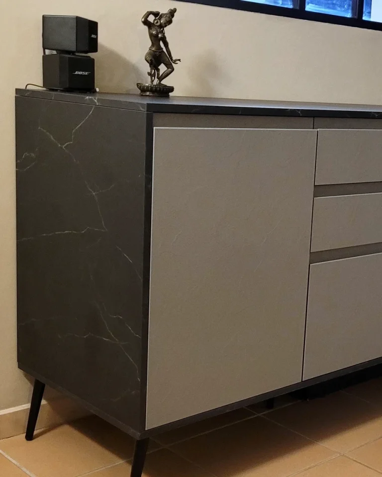 Bahut anthracite à portes et tiroirs, plan foncé et pieds fins, vu de face dans une pièce à vivre