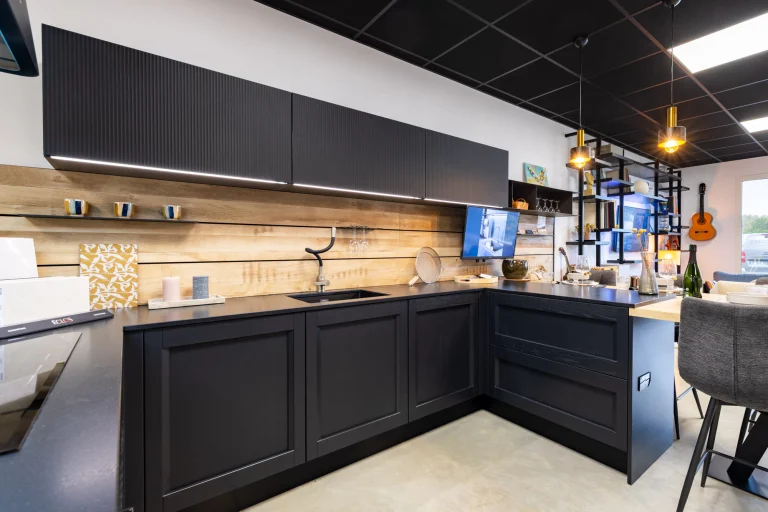 Cuisine anthracite en L à crédence bois et plan foncé, meubles hauts à façades striées, showroom MT Cuisine à Portet-sur-Garonne
