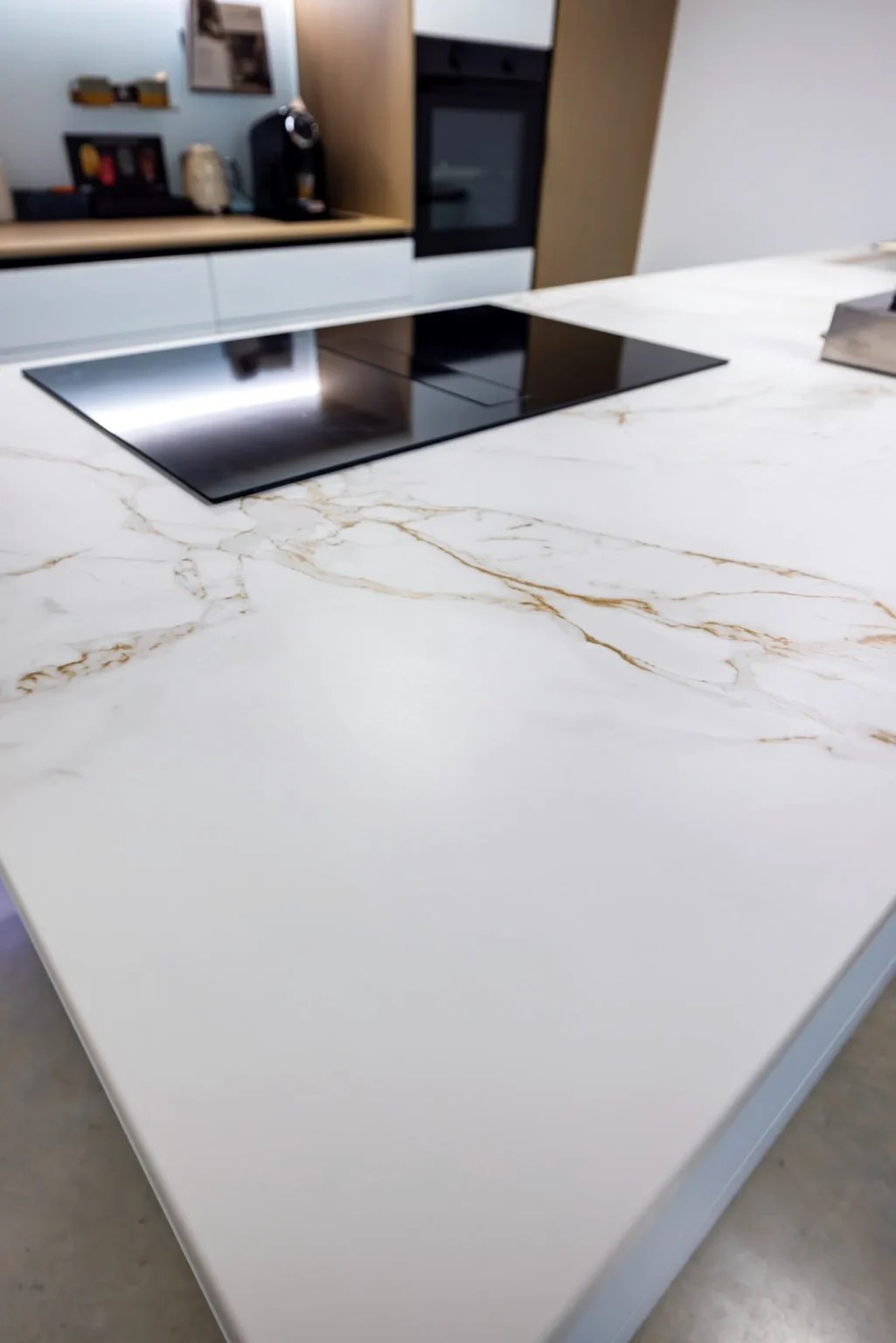 Plan de travail blanc veiné doré et plaque à induction affleurante au showroom MT Cuisine de Portet-sur-Garonne