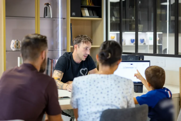 Thomas échange avec un couple devant l’écran de conception au showroom MT Cuisine de Portet-sur-Garonne